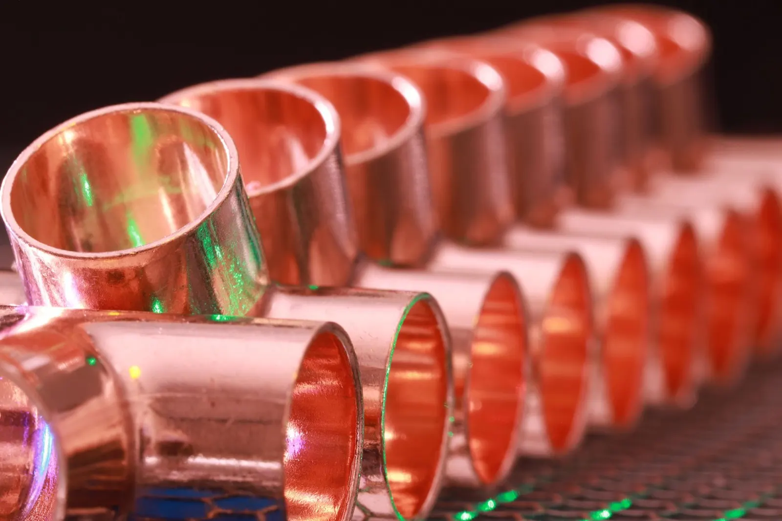 Row of new copper pipe fittings in close-up