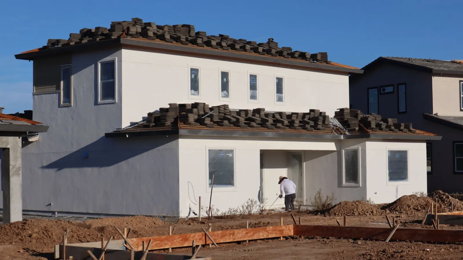 Stacks of roof tiles staged on the roof of a new house under construction