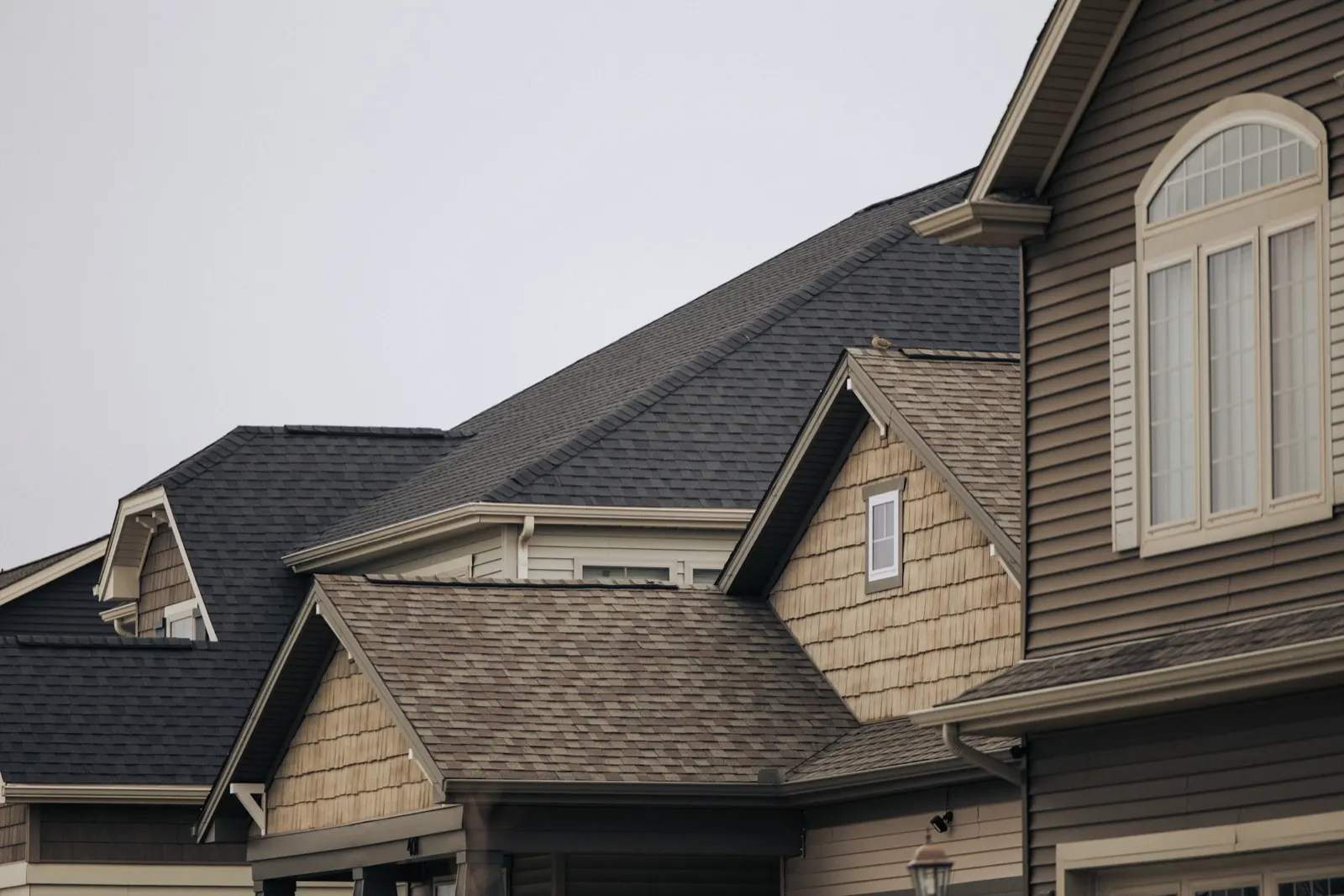Row of houses with finished brown asphalt shingle roofs