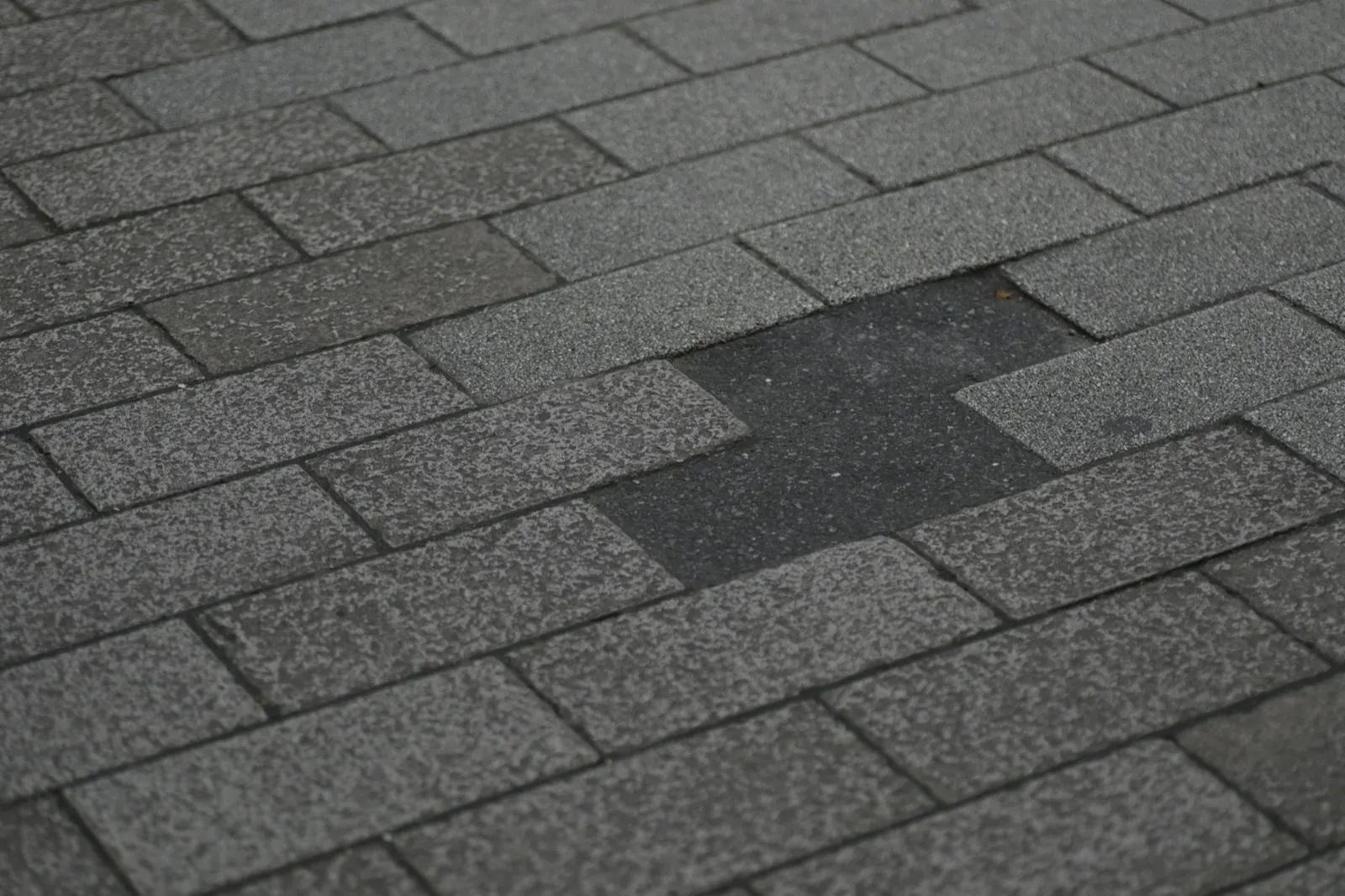 Asphalt shingle roof with a patch of missing shingles